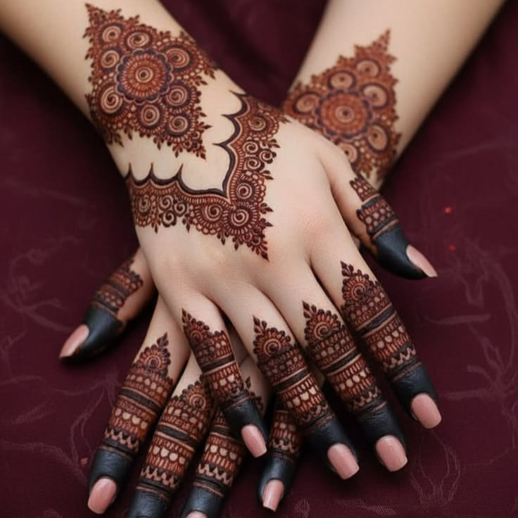 Two hands with intricate mehndi designs on the back and fingers, placed over a dark red fabric background.”